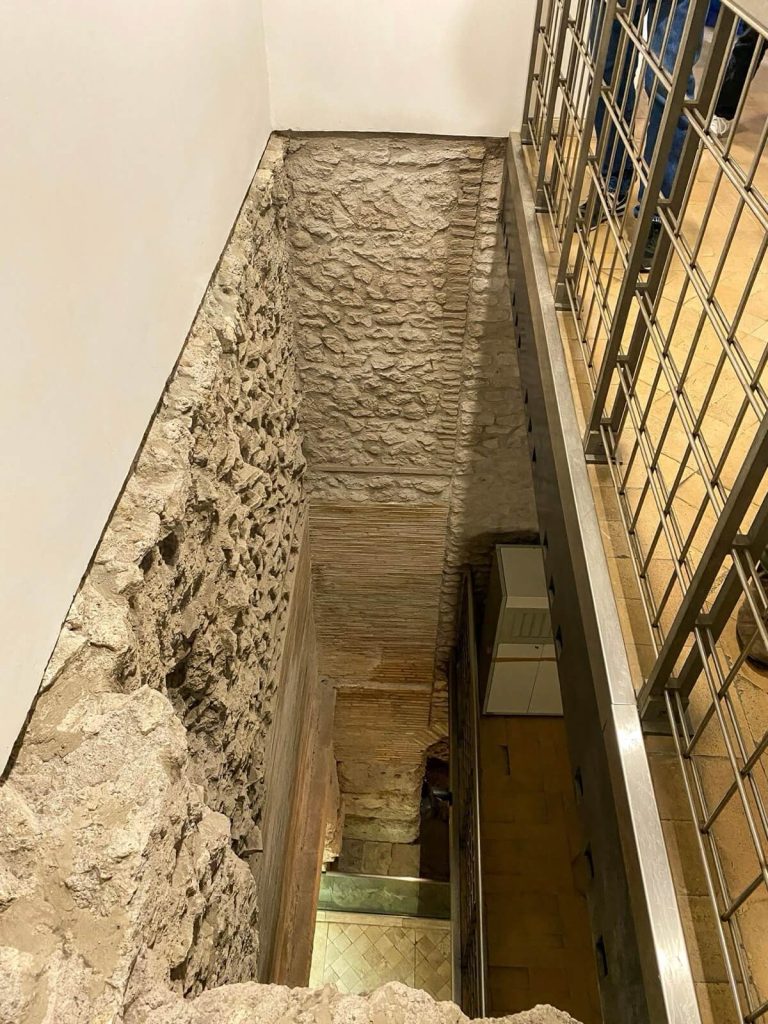 Stratificazioni murarie alla Crypta Balbi di Roma, con pareti in pietra e laterizio che mostrano diversi livelli storici sovrapposti.